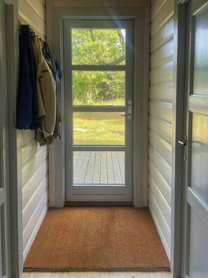 A door with a view of a grassy yard and a wooden deck. - Renovated 1970s holiday home by the dunes (Nr. Nebel)