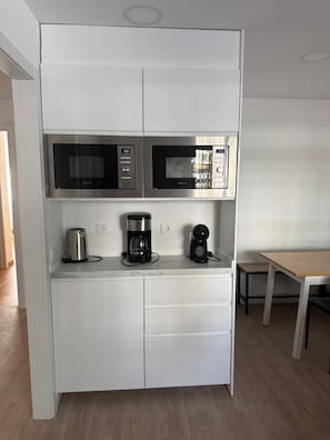 A compact kitchen with two built-in microwaves, a coffee maker, and a kettle on the countertop. - Grandparents' House (Torremolinos)