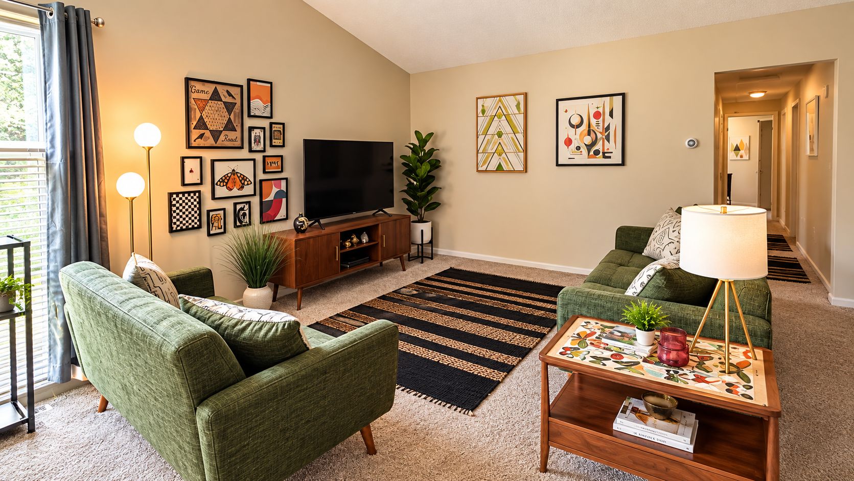 A living room with two green sofas, a flat-screen TV, a wooden cabinet, and a patterned rug.