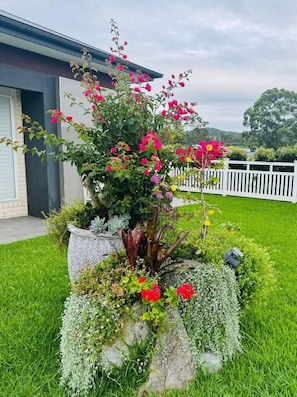 A garden with a variety of plants and flowers, a white fence, and a building in the background. - Amazon Artistry 5 bedrooms Full House (Upper Kedron)