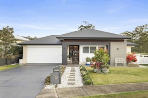 A residential house with a garage, a front porch with potted plants, and a well-maintained lawn. - Amazon Artistry 5 bedrooms Full House (Upper Kedron)
