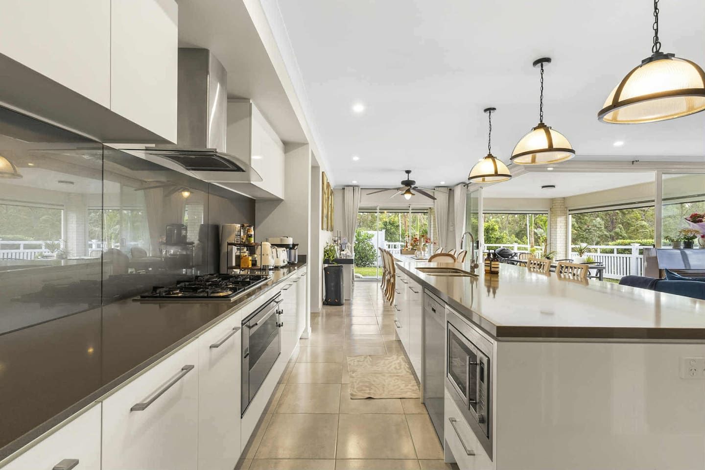 A modern kitchen with a central island, stainless steel appliances, and pendant lighting.