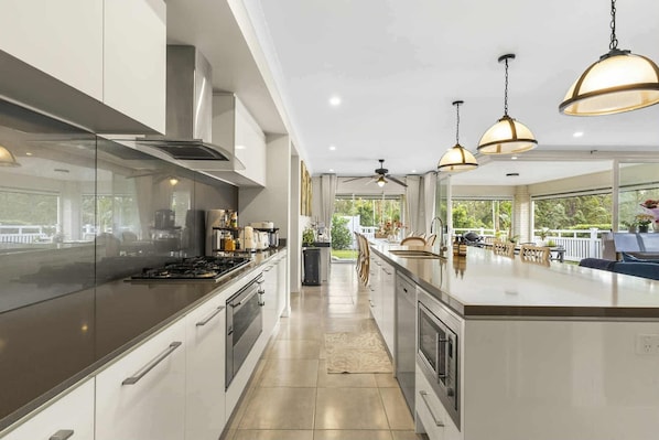 A modern kitchen with a central island, stainless steel appliances, and pendant lighting.