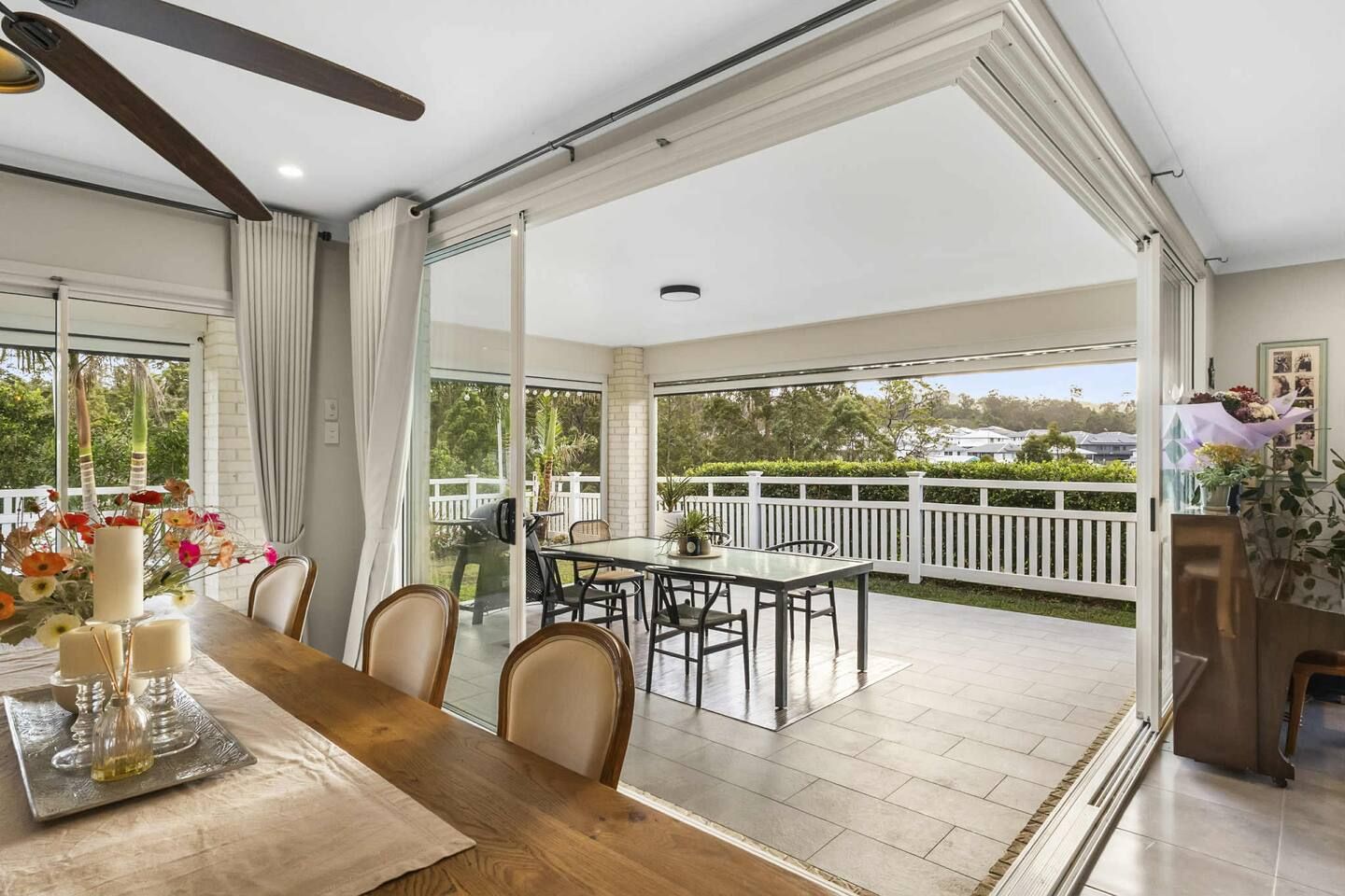 Un amplio patio con mesa, sillas y vistas del paisaje circundante.
