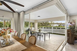 A spacious patio area with a dining table, chairs, and a view of the surrounding landscape.
