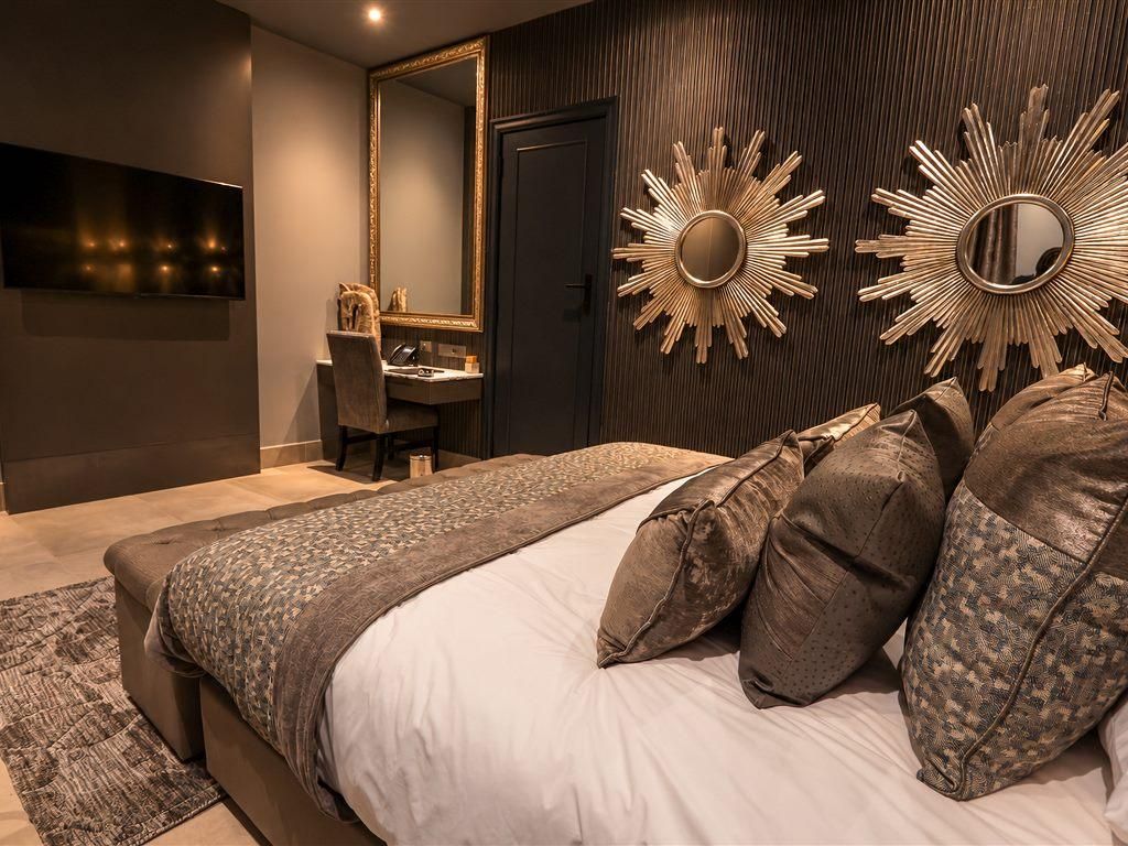Un dormitorio moderno con una cama grande, un escritorio y un espejo.