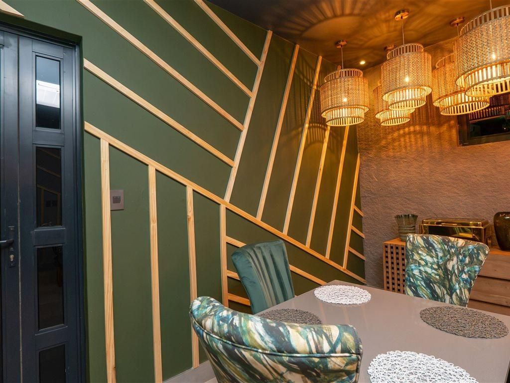 Un espace repas comprenant une table, des chaises et des luminaires suspendus.