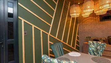 Un espace repas comprenant une table, des chaises et des luminaires suspendus.