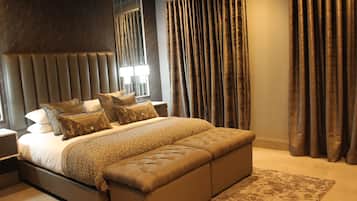 A modern bedroom with a large bed, a headboard, and a bench.