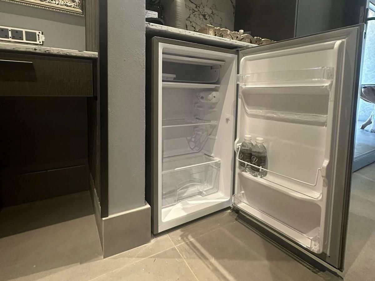 Una cocina moderna con refrigerador integrado, encimera y salpicadero de azulejos.
