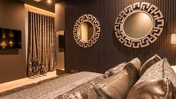 A modern room with a sofa, two wall-mounted mirrors, a television, and a curtain.