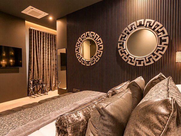 A modern room with a sofa, two wall-mounted mirrors, a television, and a curtain.