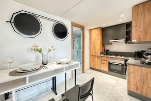 A modern kitchen with a central island, wooden cabinets, and a marble backsplash. - Modern 1-Bedroom Apartment in Casablanca | Stylish & Comfortable (Casablanca)
