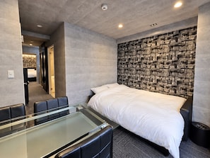 A modern hotel room with a large bed, a glass table, and a seating area. - SLEEPLAB THE STAY Shibaura (Minato)