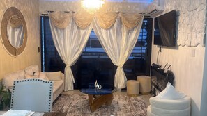 A living room with a sofa, a coffee table, and a television. - 3-bedroom apartment in fantastic Santo Domingo Este with AC and gym (Santo Domingo Este)