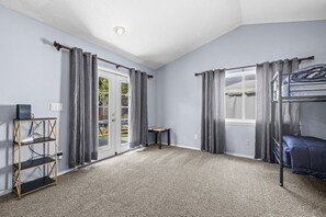 A room with a bunk bed, a desk with a computer, and a door leading to a balcony. - 4 Bedroom 3 Bathroom Great Boise Location! Easy Access-Shopping & Restaurants! (Boise)