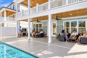 A covered outdoor patio with a pool, seating areas, and a barbecue setup. - Ocean Views-Sleeps 24-Pool-Steps to Beach (Atlantic Beach)