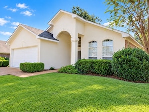 A single-story house with a garage, a covered porch, and a well-maintained lawn. - The Willow at Brenhaven, Sleeps 6 (Brandon)