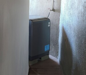 A compact, dark-colored utility room with a water heater and a visible pipe. - 'Aro'a Lodge: Exceptional views of the lagoon and Moorea (Faaa)