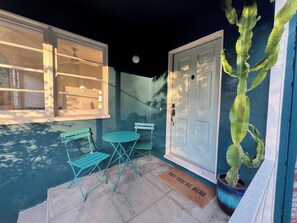 A small patio with a table and chairs, a door, and a potted plant. - Charming 3 bed, 2 bath hillside home in Los Angeles. (Los Angeles)