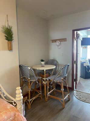 A room with a round table, four chairs, a bed, a potted plant, and a wooden shelf. - Spacious 5-bedroom house in marvelous Tavernier with Pool and Dock (Tavernier)
