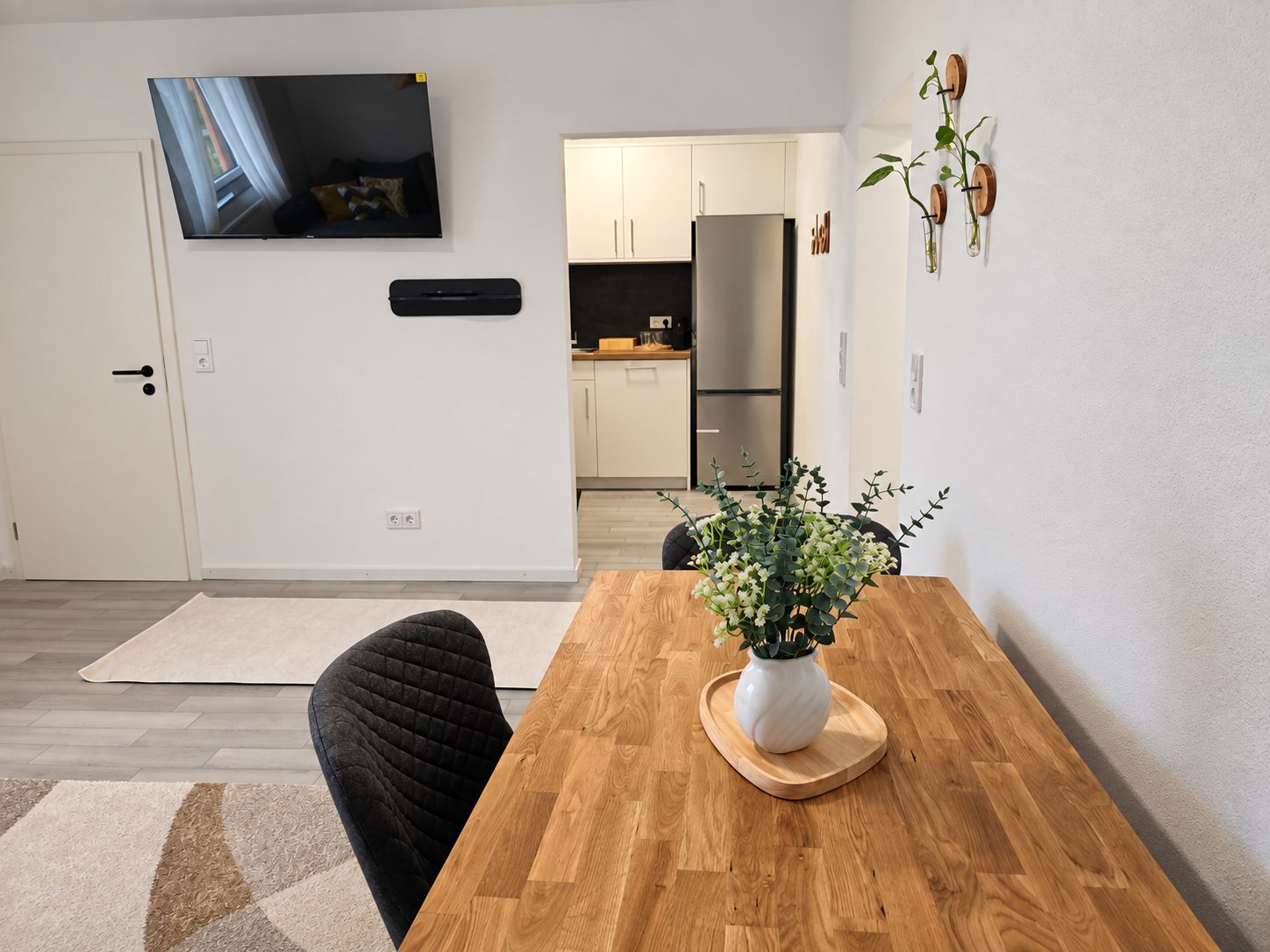 Eine moderne Küche mit weißen Schränken und einem Edelstahl-Kühlschrank.