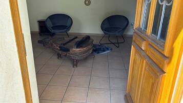 Ein Zimmer mit zwei schwarzen Stühlen, einem rustikalen Holztisch und einer Tür mit Fensterteil.