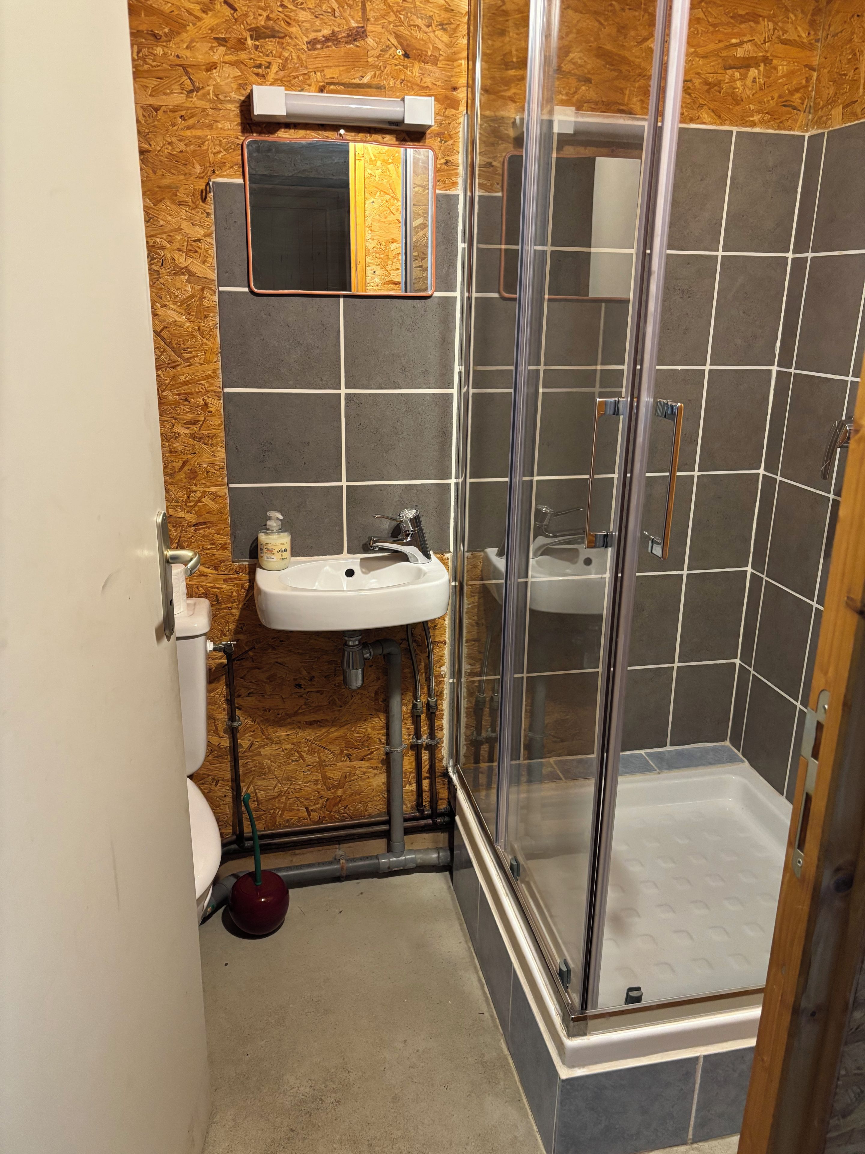 A bathroom with a shower, sink, and toilet.