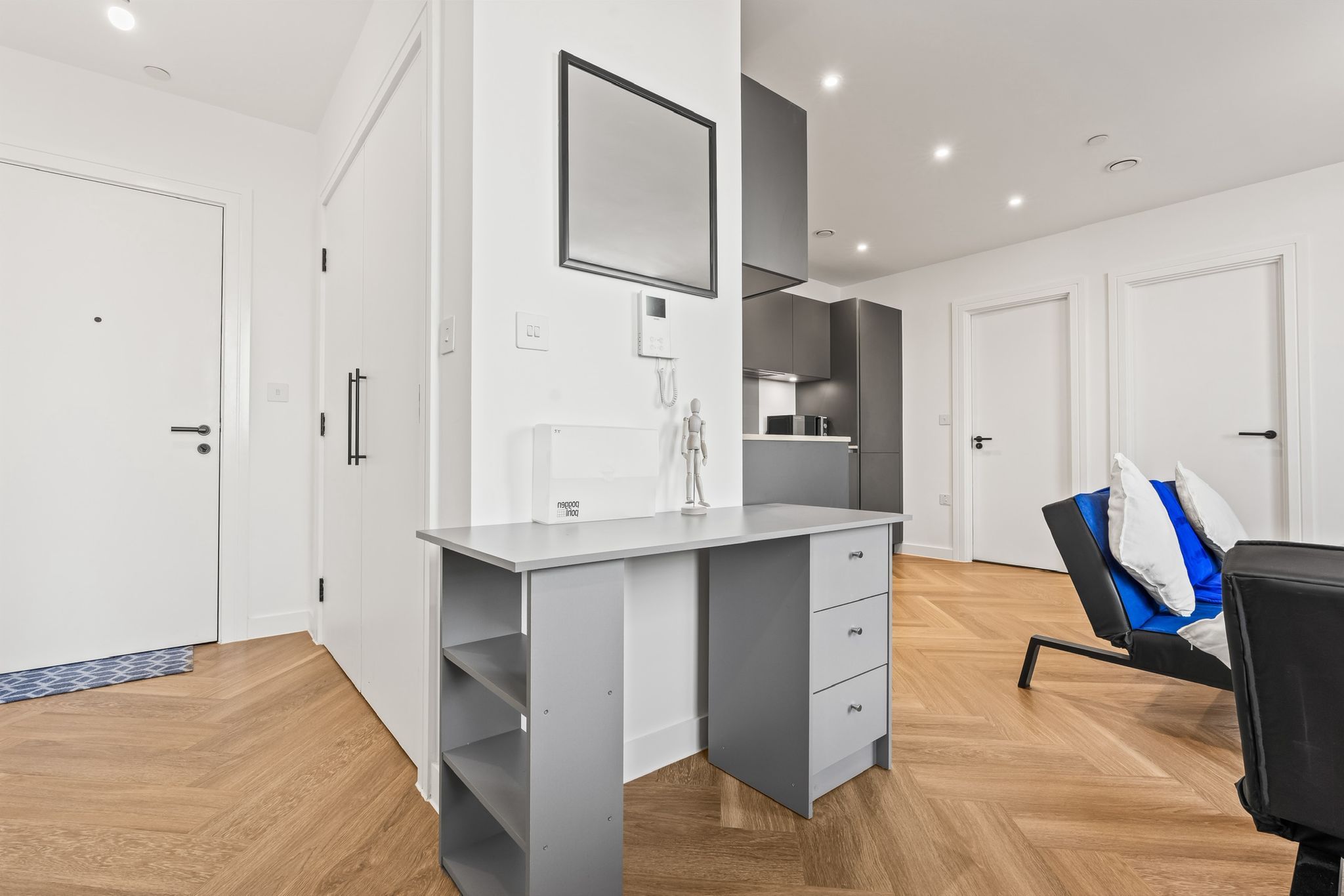 A modern room with a grey desk, a chair, and a wardrobe.