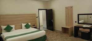 Ein Hotelzimmer mit Bett, Schreibtisch, Spiegel und Kleiderschrank.