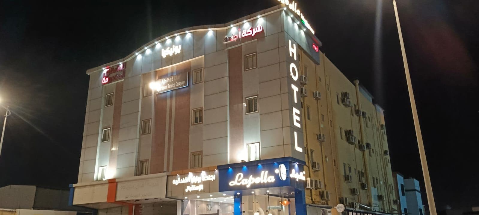 Ein Hotel mit einem gut sichtbaren 'HOTEL'-Schild, einem 'Papolla'-Restaurantschild und einem 'Sofitel'-Schild.