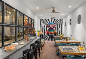 Un intérieur moderne avec un espace salon central, un comptoir de bar et une grande fresque murale.