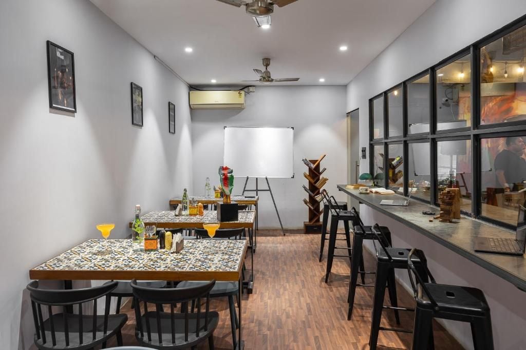 A conference room with a whiteboard, tables, chairs, and a bar area with a laptop.