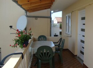 A small patio with a table and chairs, a satellite dish, and a potted plant with flowers. - Villa Damir - Petrčane (Zadar)