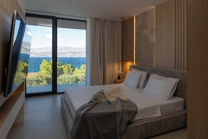 A modern hotel room with a large bed, a flat-screen TV, and a view of the sea. - Villa on Brač, 80 m from the sea, with a gym, a heated pool, a boat and driver (Splitska)