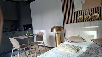 A modern bedroom with a bed, bedside tables, a desk, and a chair.