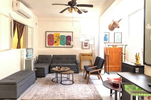 A living room with a sofa set, a coffee table, a chair, a desk, and a water dispenser. - Hidden Gem in the Zona. King Bed, Designer Reno. Private yet near It All (Puerto Vallarta)