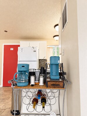 A kitchenette with a coffee maker, a kettle, and a wine bottle holder. - Mountain and Meadows, family-friendly 3BR, near I-84, parks and dining. (Mountain Home)