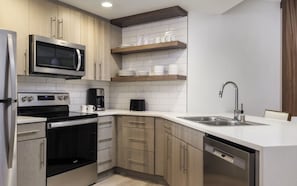 A modern kitchen with stainless steel appliances, wooden cabinets, and a white countertop. - Super Bowl, Presidents' Day & Valentine's Week-2BR Villa, Marriott Newport Coast (Newport Beach)