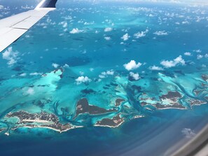 An aerial view of a coastal area with clear blue waters, visible landmasses, and a clear sky. - Coming Soon, Spectacular Beachfront Villa, Bahama Bliss  (Wemyss)