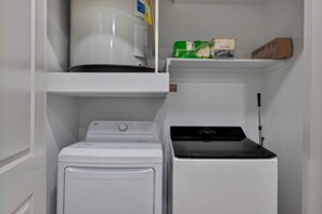 A compact laundry area with a front-loading washer and a top-loading dryer. - King 1BR near PGA Frisco, sleeps 3, pets OK (Frisco)
