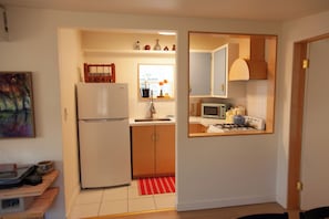 A kitchen with a refrigerator, microwave, stove, and cabinets.