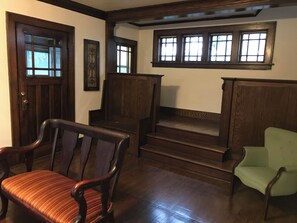 A room with a wooden staircase, a green armchair, and a striped chair. - Tranquil 4-bedroom house 2 miles from ND (South Bend)