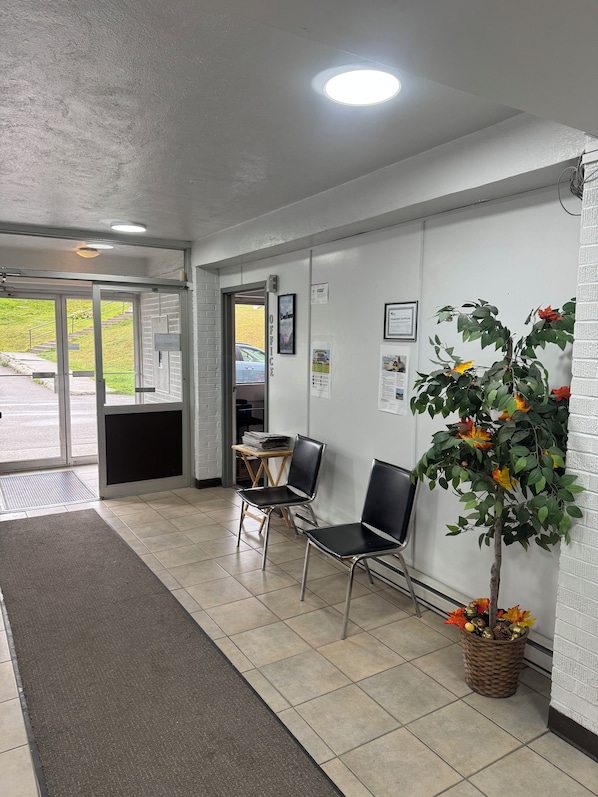 A reception area with a waiting area, a reception desk, and a wall-mounted plant.