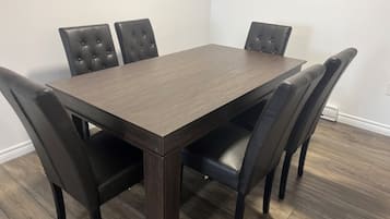 A rectangular dining table with six upholstered chairs.
