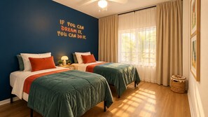 A bedroom with two beds, a motivational quote on the wall, a window with curtains, and a wooden floor. - Lakeview 3-Bedroom Resort Condo | 15 Minutes from Disney | 4 Pools (Davenport)