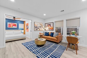 A modern living room with a sofa, coffee table, and dining area. - 2-bedroom Duo apartment in charming Dallas Bishop Arts Downtown (Dallas)