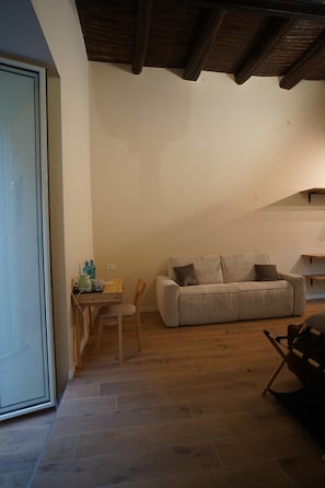 Een woonkamer met een bank, een houten tafel en een stoel.
