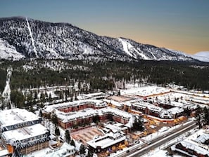 Un pueblo cubierto de nieve con edificios y una montaña al fondo.