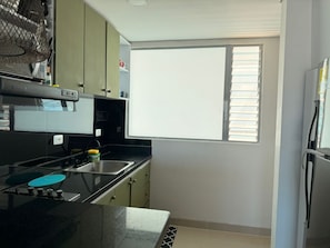 A kitchen with a window, a sink, and a stove. - Apartment at Hotel Sonesta - Morros with sea view and direct beach access | Pool (Cartagena de Indias)